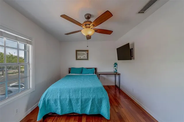 a bedroom with a bed and a flat tv screen on the dresser