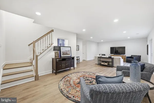 a living room with furniture a flat screen tv and kitchen view