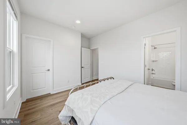 a bedroom with a bed and wooden floor