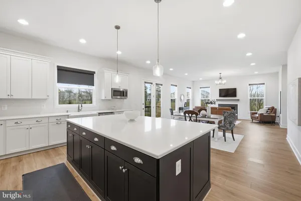 a large kitchen with kitchen island a sink table and chairs
