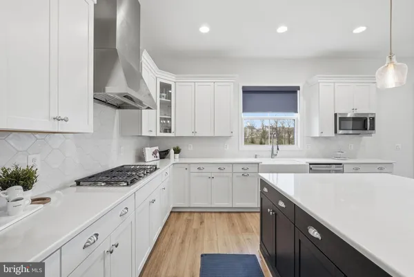 a kitchen with cabinets appliances a sink and a window