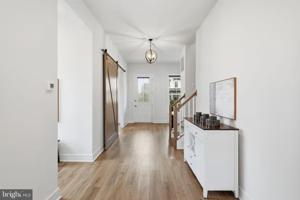 a view of a hallway with wooden floor and staircase