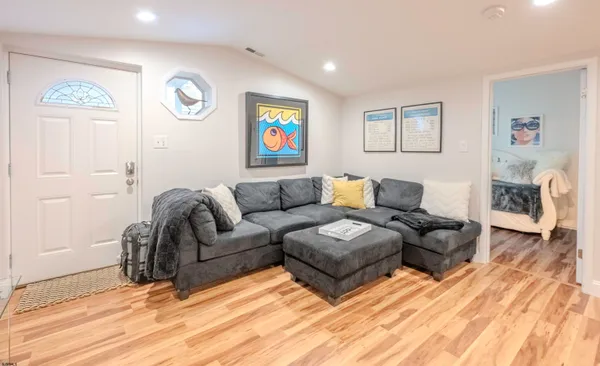 a living room with couches and a potted plant
