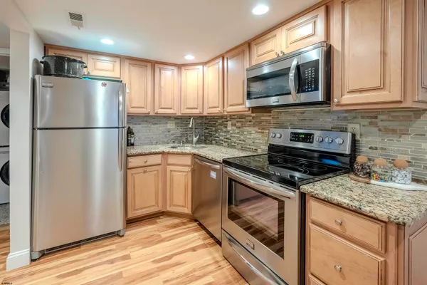 a kitchen with granite countertop a refrigerator stove and microwave