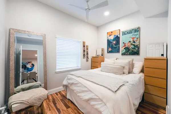 a bedroom with a large bed and a painting on the wall