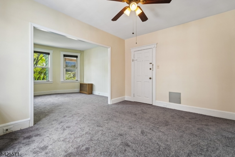 7 Beekman Street, Unit 2 Bloomfield, NJ 07003 - Photo 6 of 27 an empty room with windows and chandelier fan
