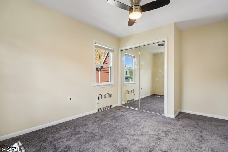 7 Beekman Street, Unit 2 Bloomfield, NJ 07003 - Photo 9 of 27 an empty room with windows and ceiling fan
