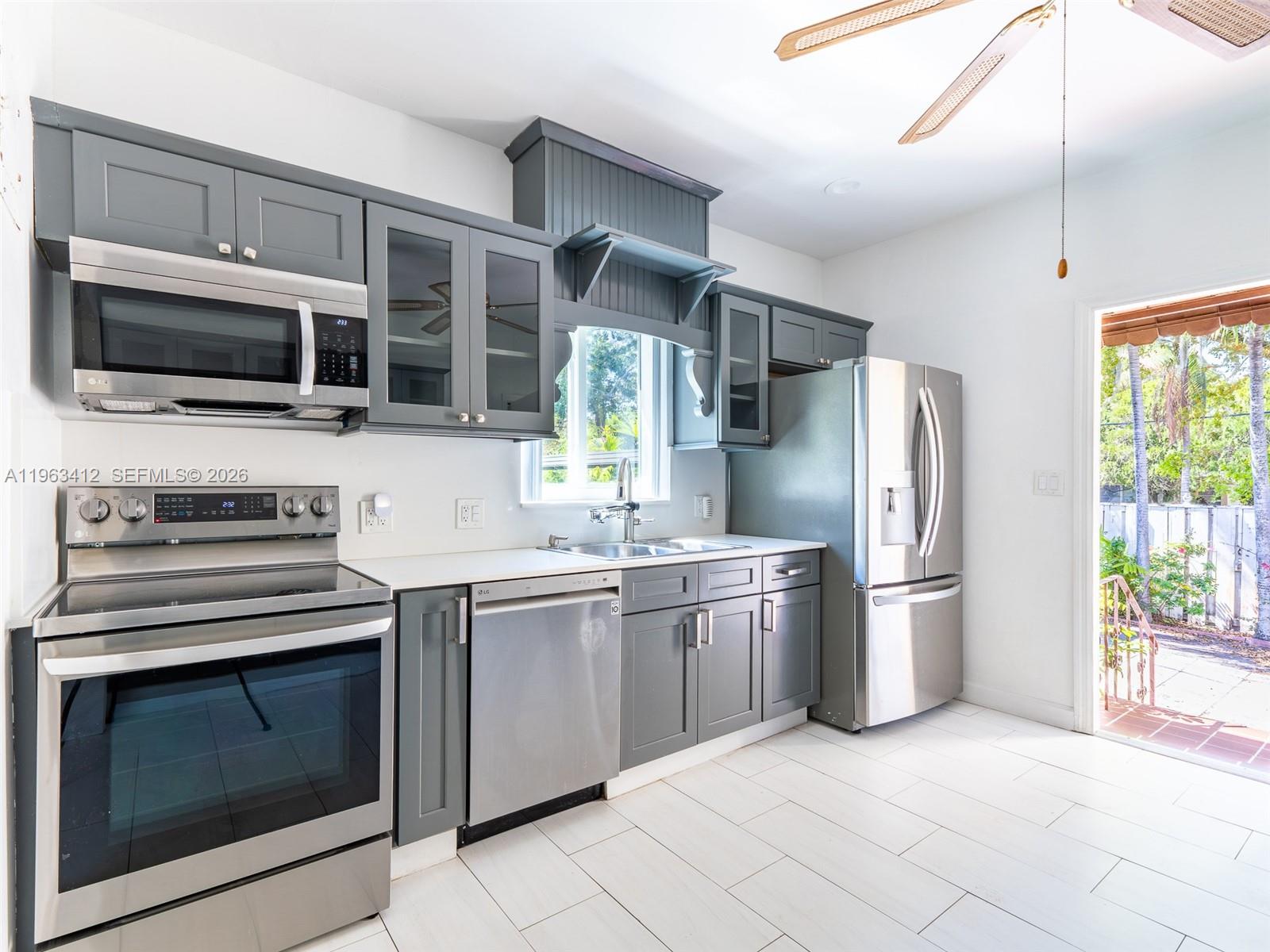 630 Southwest 25th Road Miami, FL 33129 - Photo 12 of 35 a kitchen with stainless steel appliances granite countertop a stove top oven a refrigerator and white cabinets