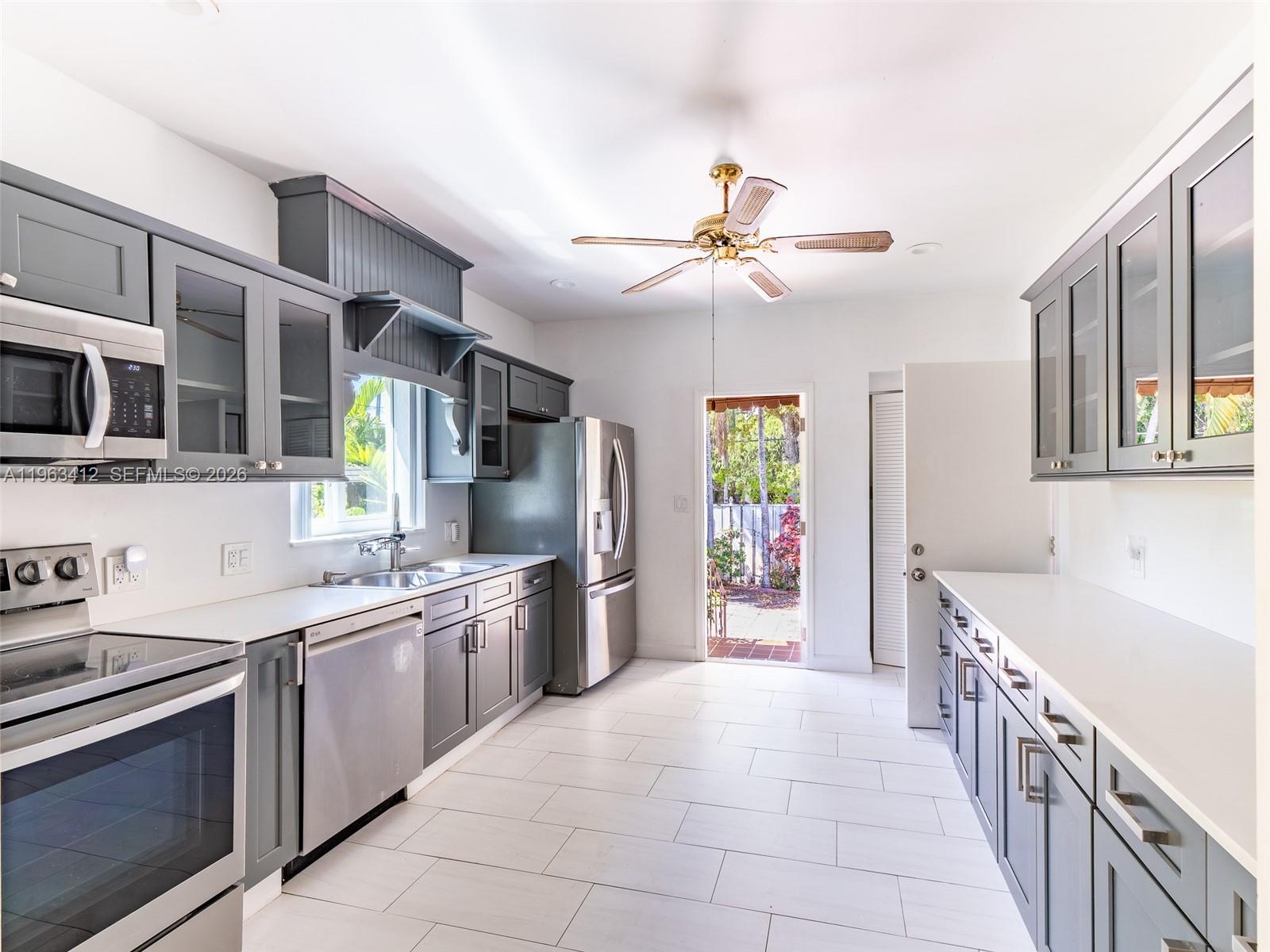 630 Southwest 25th Road Miami, FL 33129 - Photo 13 of 35 a large kitchen with a stove top oven a sink a counter space and cabinets