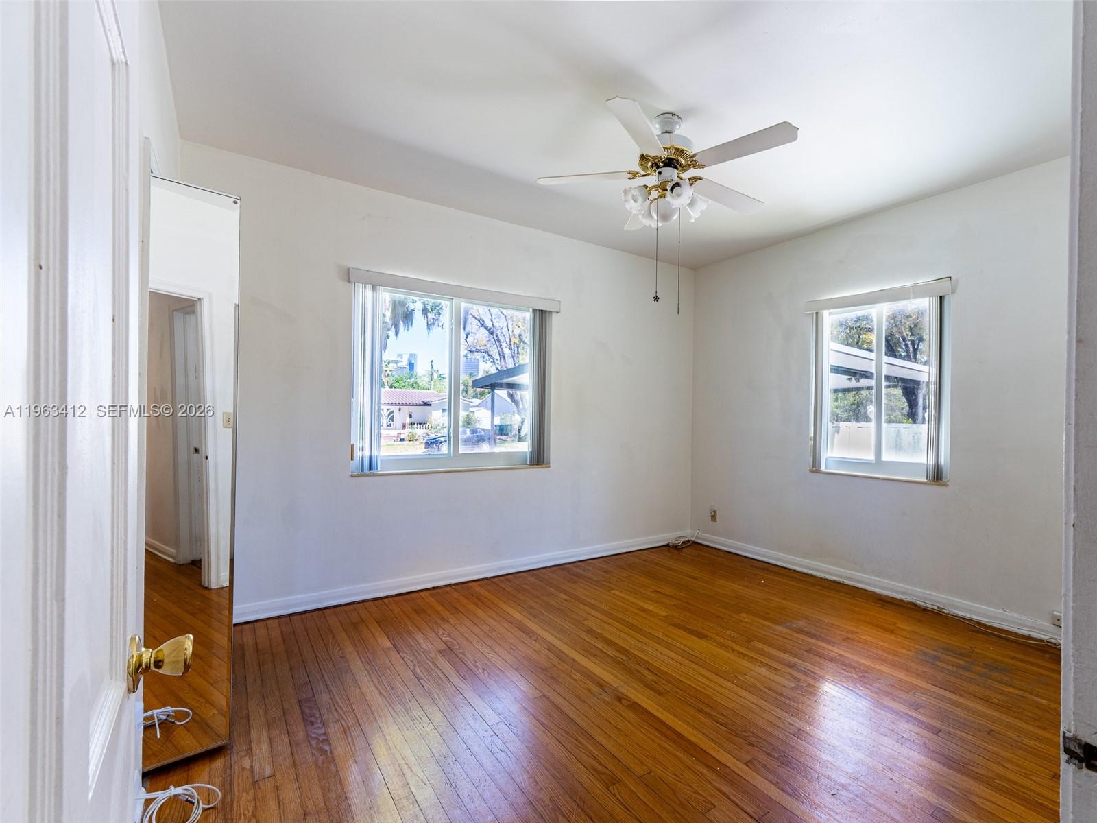 630 Southwest 25th Road Miami, FL 33129 - Photo 15 of 35 a view of an empty room with wooden floor and a window