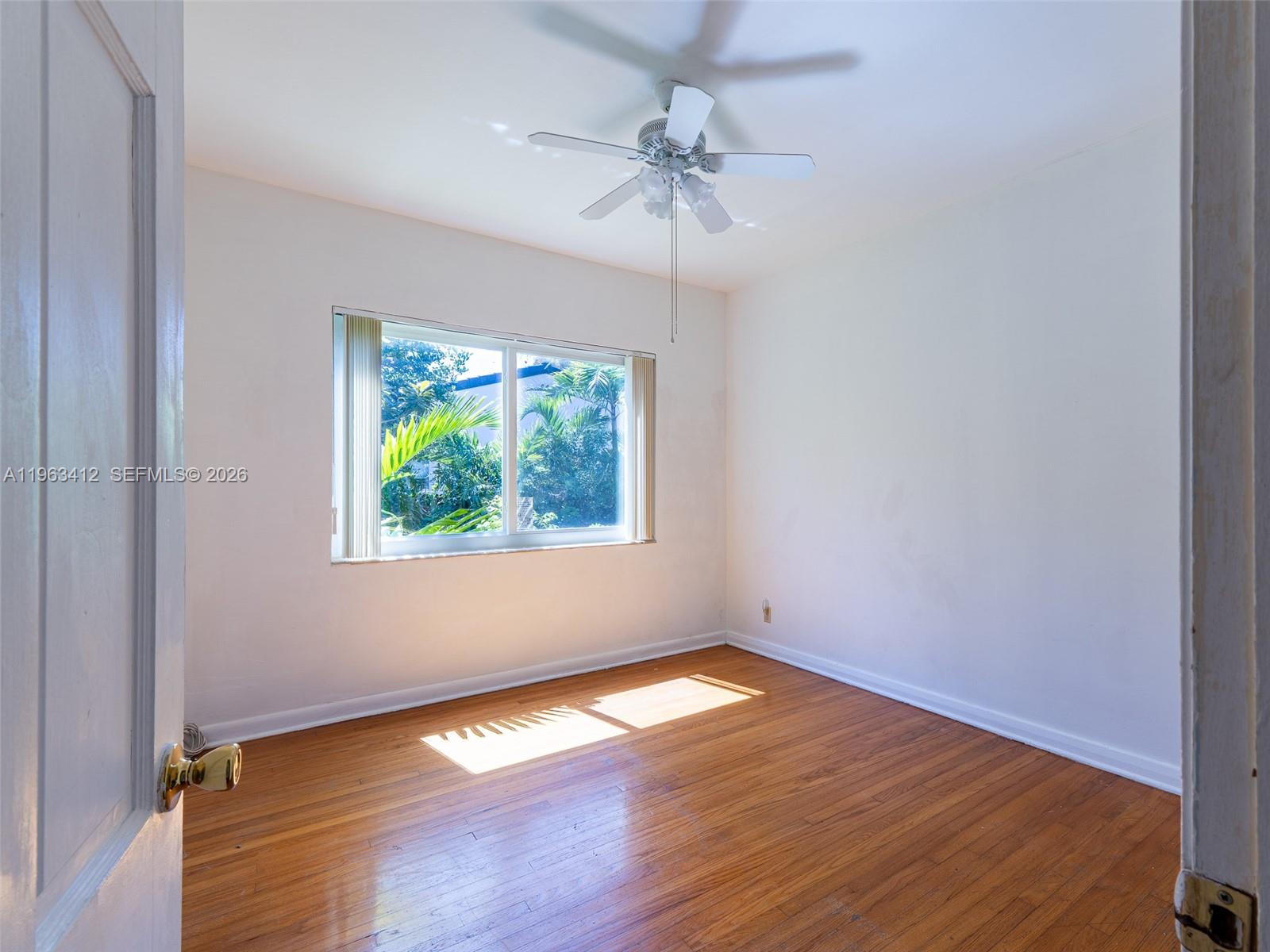 630 Southwest 25th Road Miami, FL 33129 - Photo 19 of 35 an empty room with a window and wooden floor