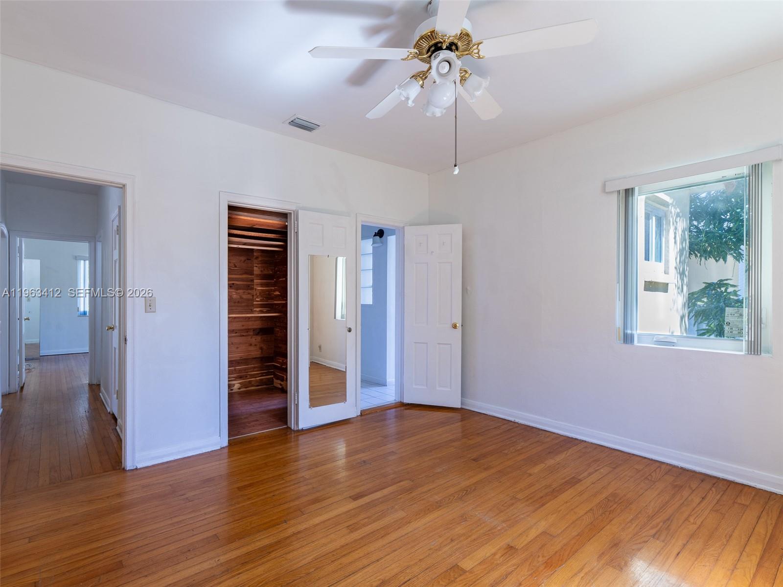 630 Southwest 25th Road Miami, FL 33129 - Photo 21 of 35 a view of an empty room with a window and wooden floor