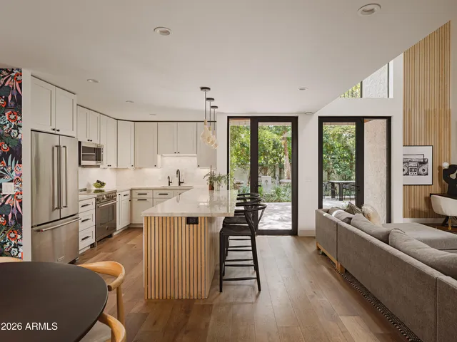 a living room with stainless steel appliances granite countertop furniture a refrigerator a stove top oven and a refrigerator