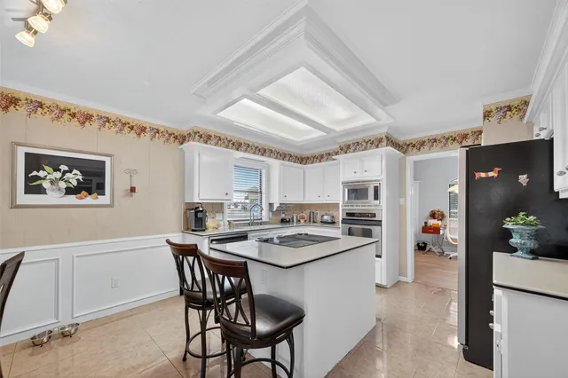 a kitchen with stainless steel appliances granite countertop a stove refrigerator and cabinets