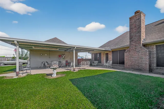 a view of a house with a big yard and a large tree