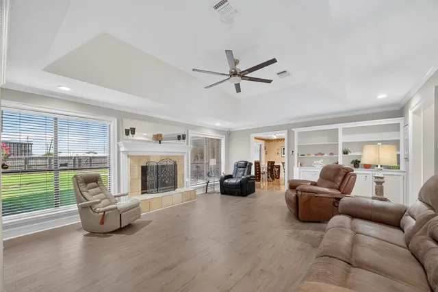 a living room with furniture and a fireplace with wooden floor