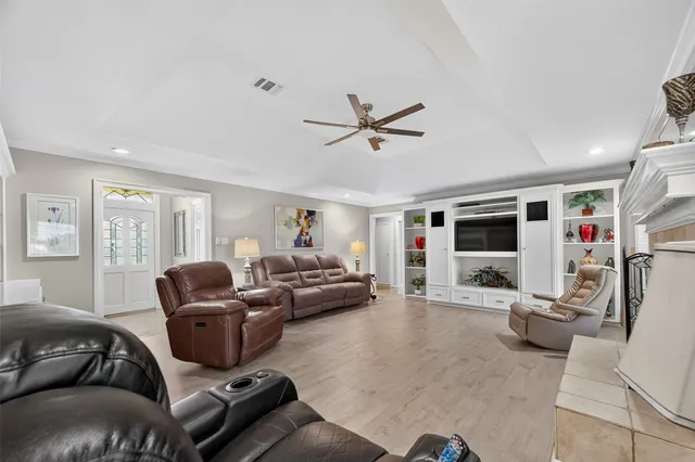 a living room with furniture ceiling fan and a flat screen tv