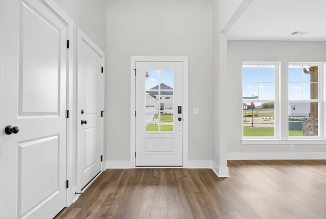 a view of empty room with wooden floor and entryway