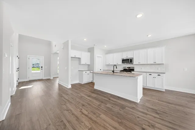 a kitchen with granite countertop white cabinets and window