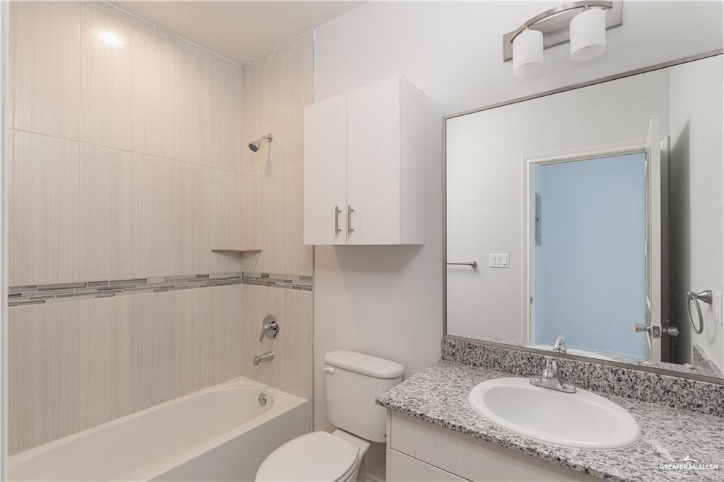 1306 Royola Street Mission, TX 78572 - Photo 15 of 16 a bathroom with a granite countertop sink toilet and shower