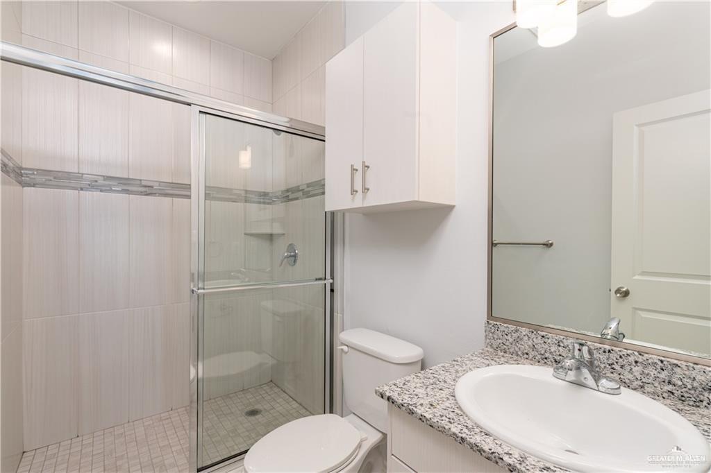 1306 Royola Street Mission, TX 78572 - Photo 9 of 16 a bathroom with a granite countertop sink toilet and shower