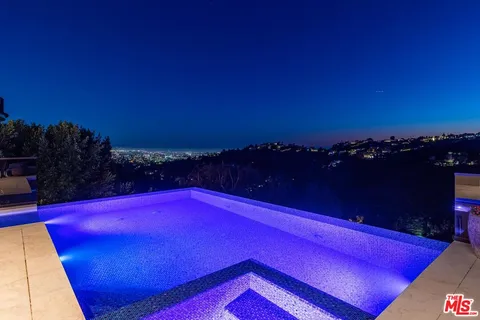 a blue swimming pool with outdoor seating and yard