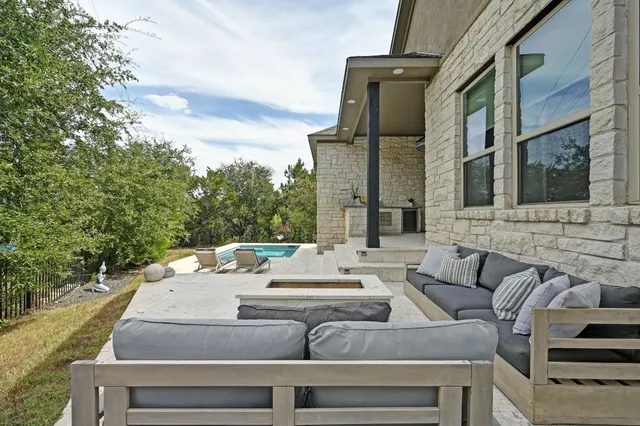 a view of a patio with couches table and chairs with wooden floor and fence