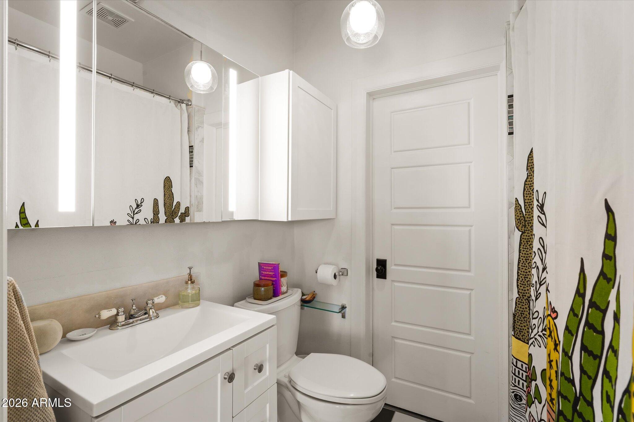 1348 East Fillmore Street Phoenix, AZ 85006 - Photo 30 of 41 a bathroom with a sink a toilet and a mirror