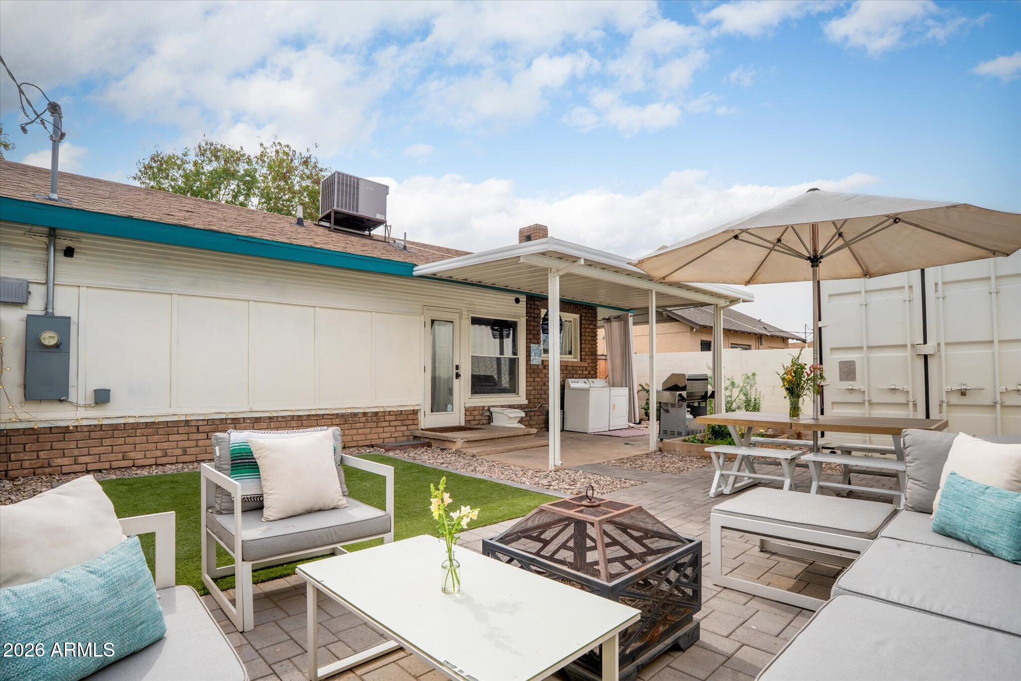 1348 East Fillmore Street Phoenix, AZ 85006 - Photo 32 of 41 a view of a patio with couches table and chairs under an umbrella with a barbeque