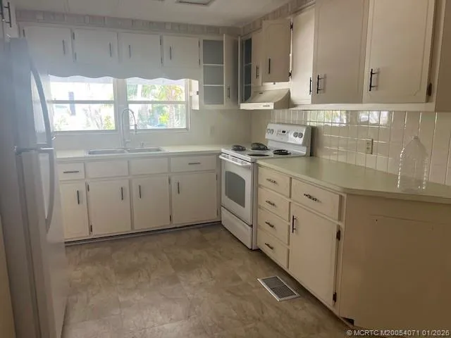 a view of an empty room with window and bathroom