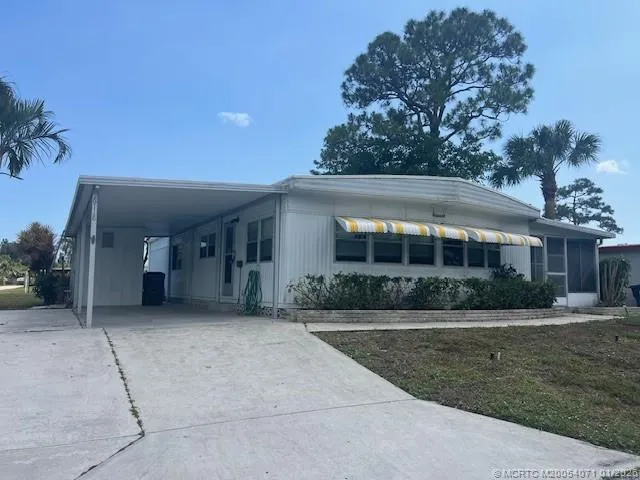 a front view of a house with a yard and potted plants