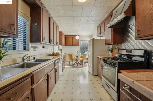 a kitchen with stainless steel appliances granite countertop a stove a sink and a refrigerator