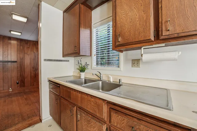 a view of a kitchen with a sink and dishwasher a refrigerator with wooden floor