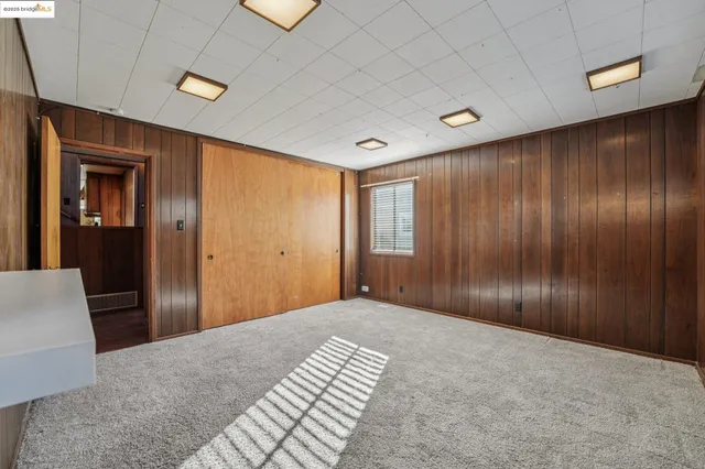 a view of a livingroom with wooden floor and kitchen space