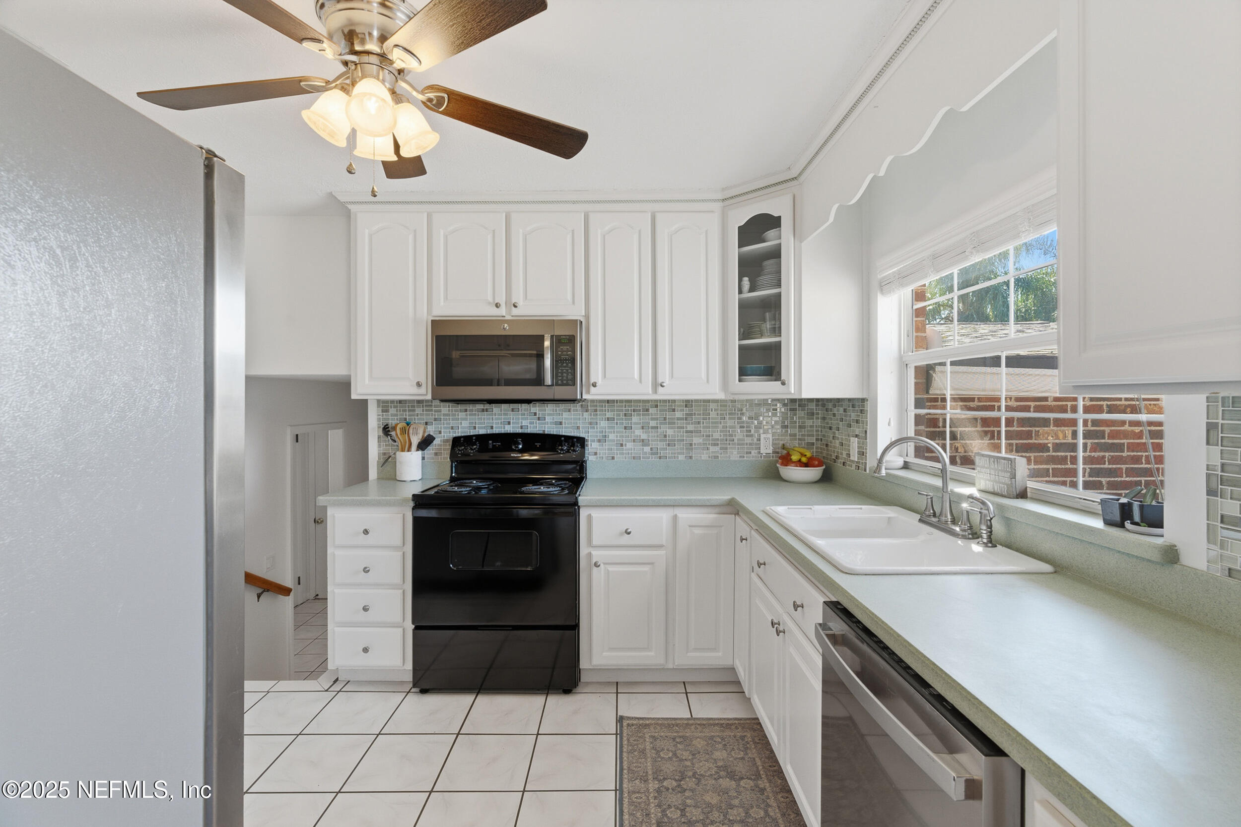 276 Baisden Road Jacksonville, FL 32218 - Photo 11 of 71 a kitchen with stainless steel appliances a stove sink microwave and cabinets