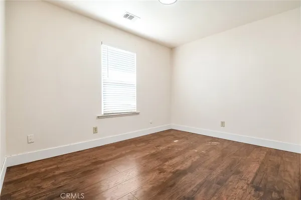 an empty room with wooden floor and window