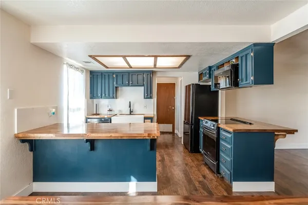 a view of kitchen with kitchen island stainless steel appliances a sink stove and refrigerator