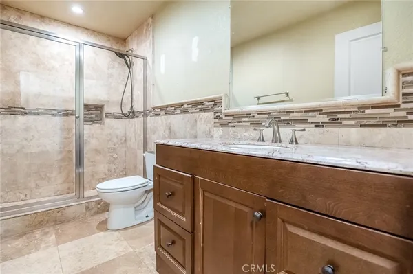 a bathroom with a granite countertop sink toilet and shower