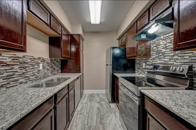 a kitchen with stainless steel appliances granite countertop sink stove and cabinets