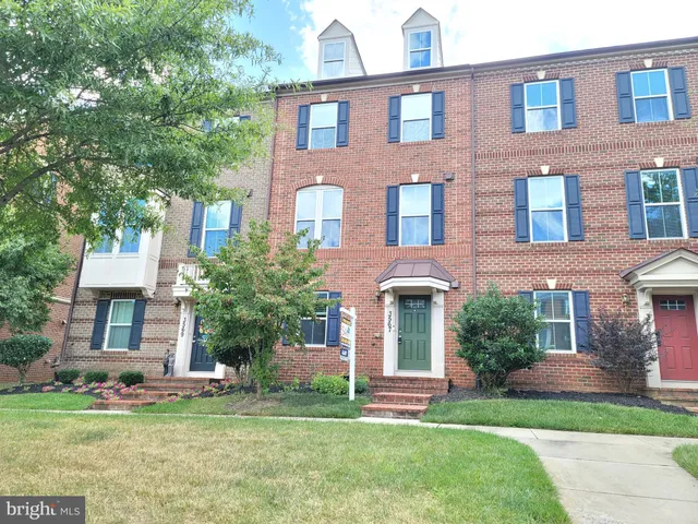 front view of a brick house with a yard