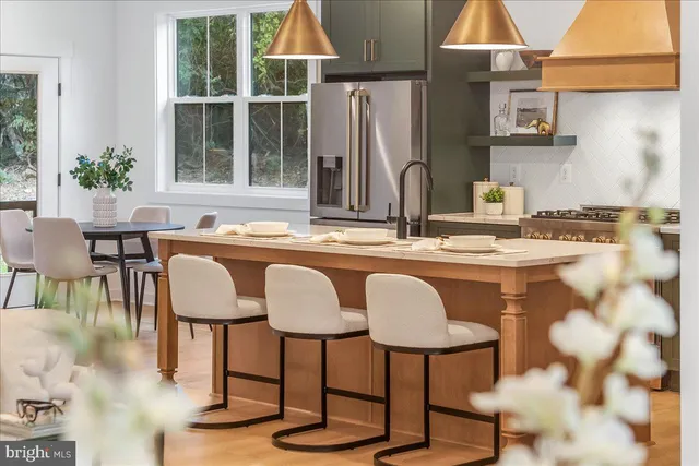 a kitchen with stainless steel appliances granite countertop a table and chairs in it