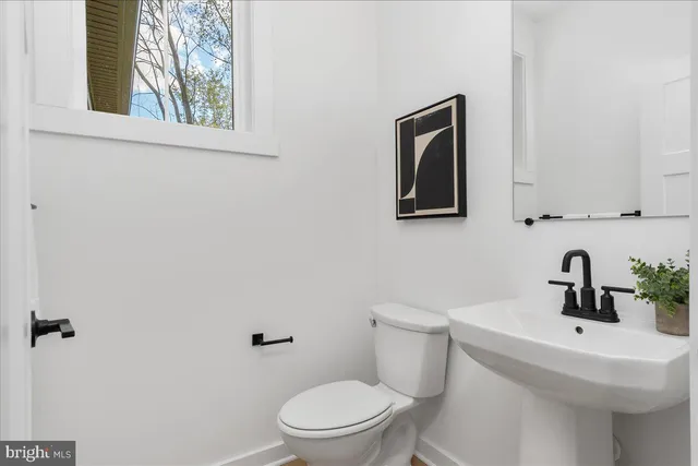 a bathroom with a toilet a sink and mirror