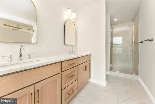a bathroom with a double vanity sink mirror and shower