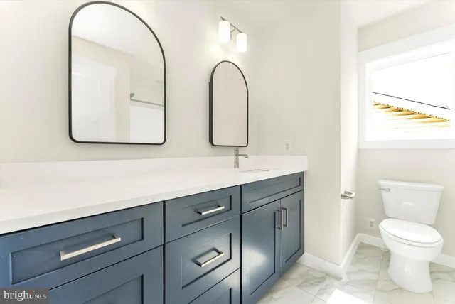 a bathroom with a toilet sink and mirror