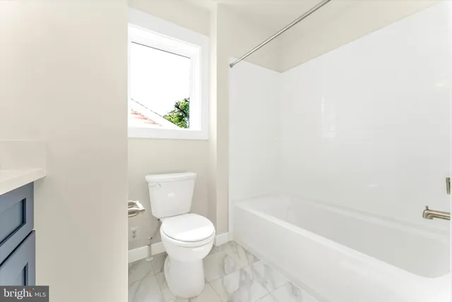 a white toilet sitting next to a bathtub