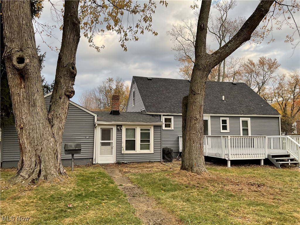 8002 Stockbridge Road Mentor, OH 44060 - Photo 17 of 19 Rear view of property featuring a yard, a shingled roof, a chimney, and a wooden deck