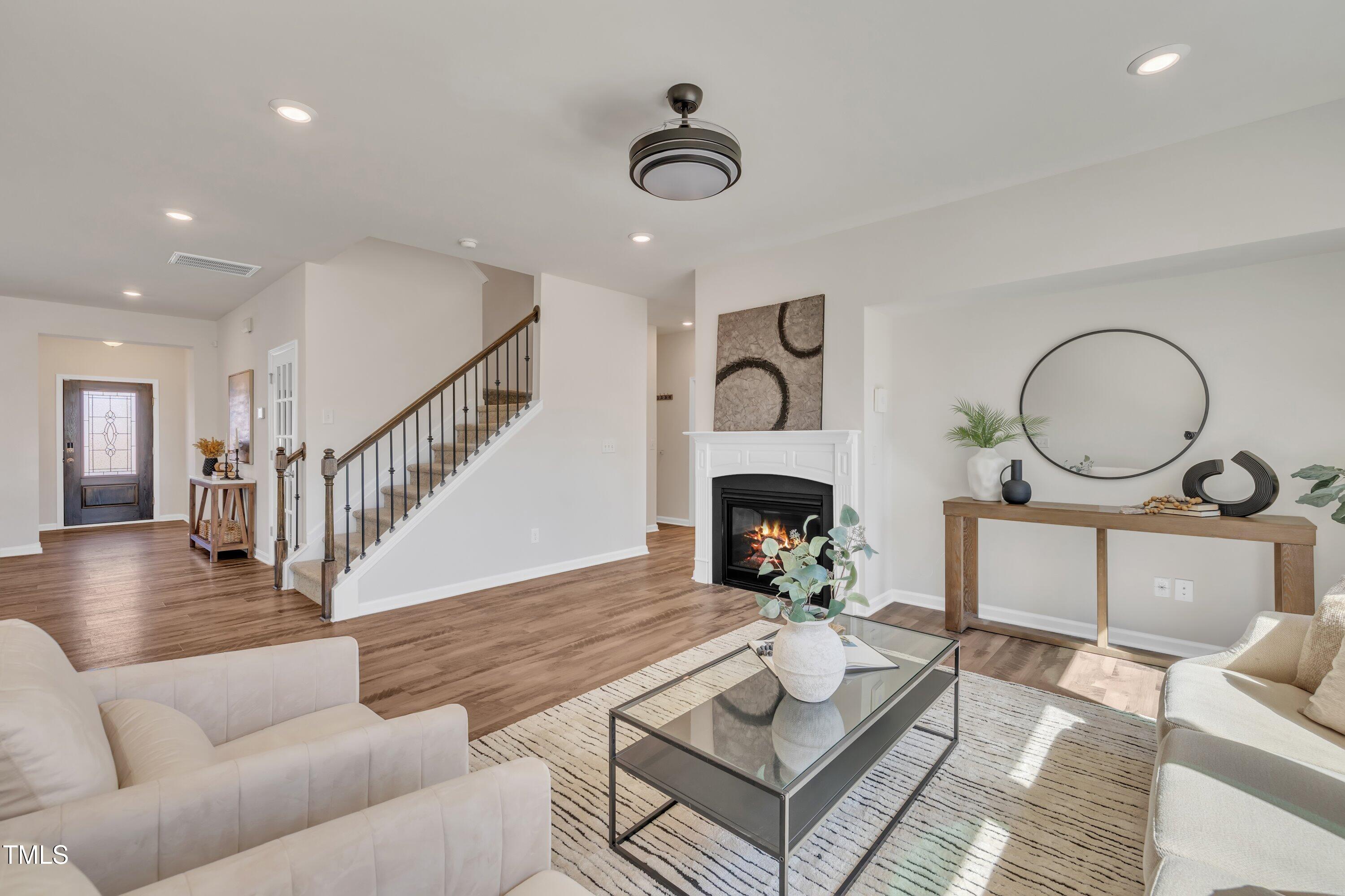 3381 Lovage Drive Apex, NC 27502 - Photo 25 of 50 a living room with furniture a rug and a fireplace