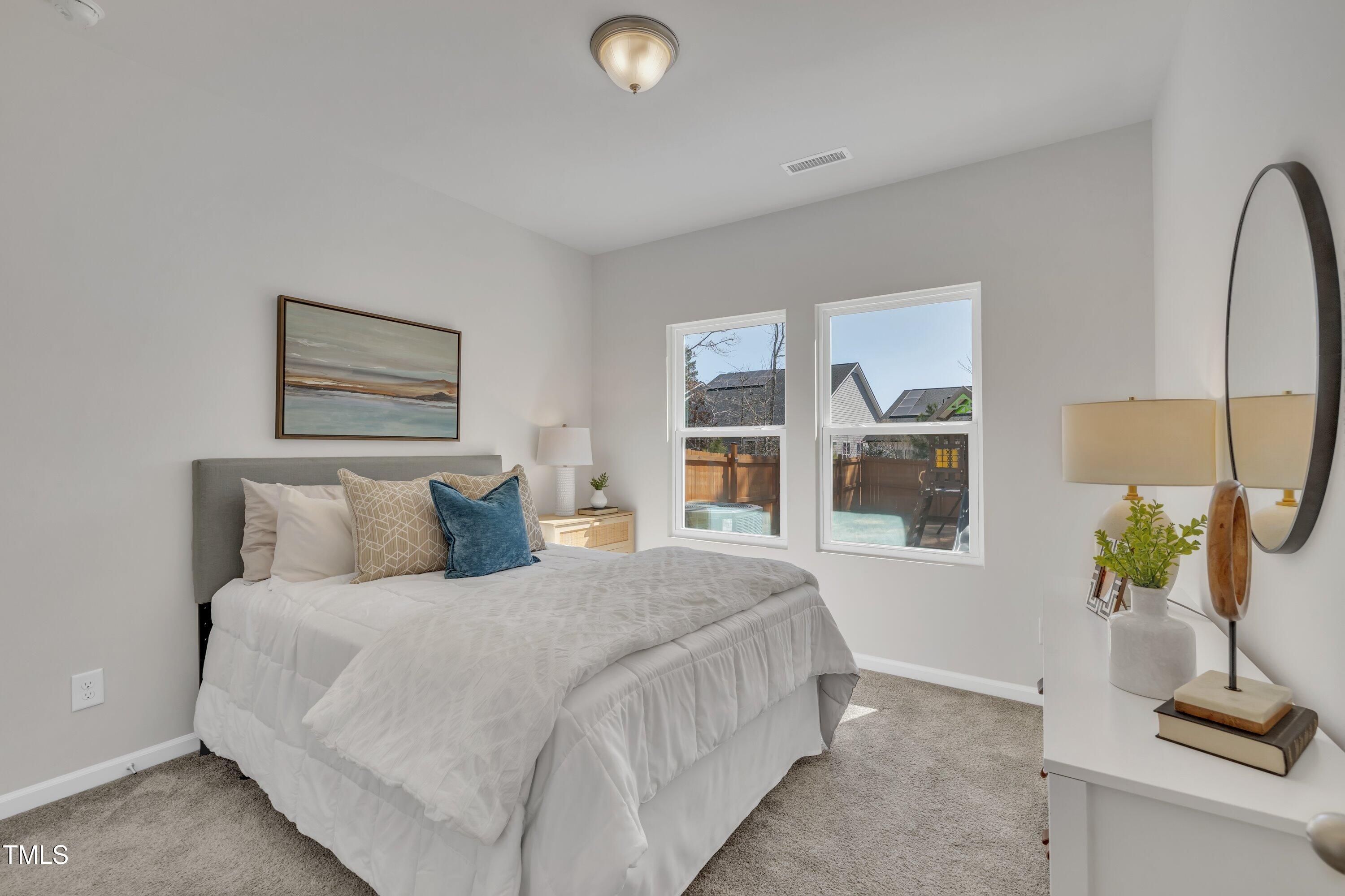3381 Lovage Drive Apex, NC 27502 - Photo 26 of 50 a bedroom with a bed a potted plant on dresser and a window