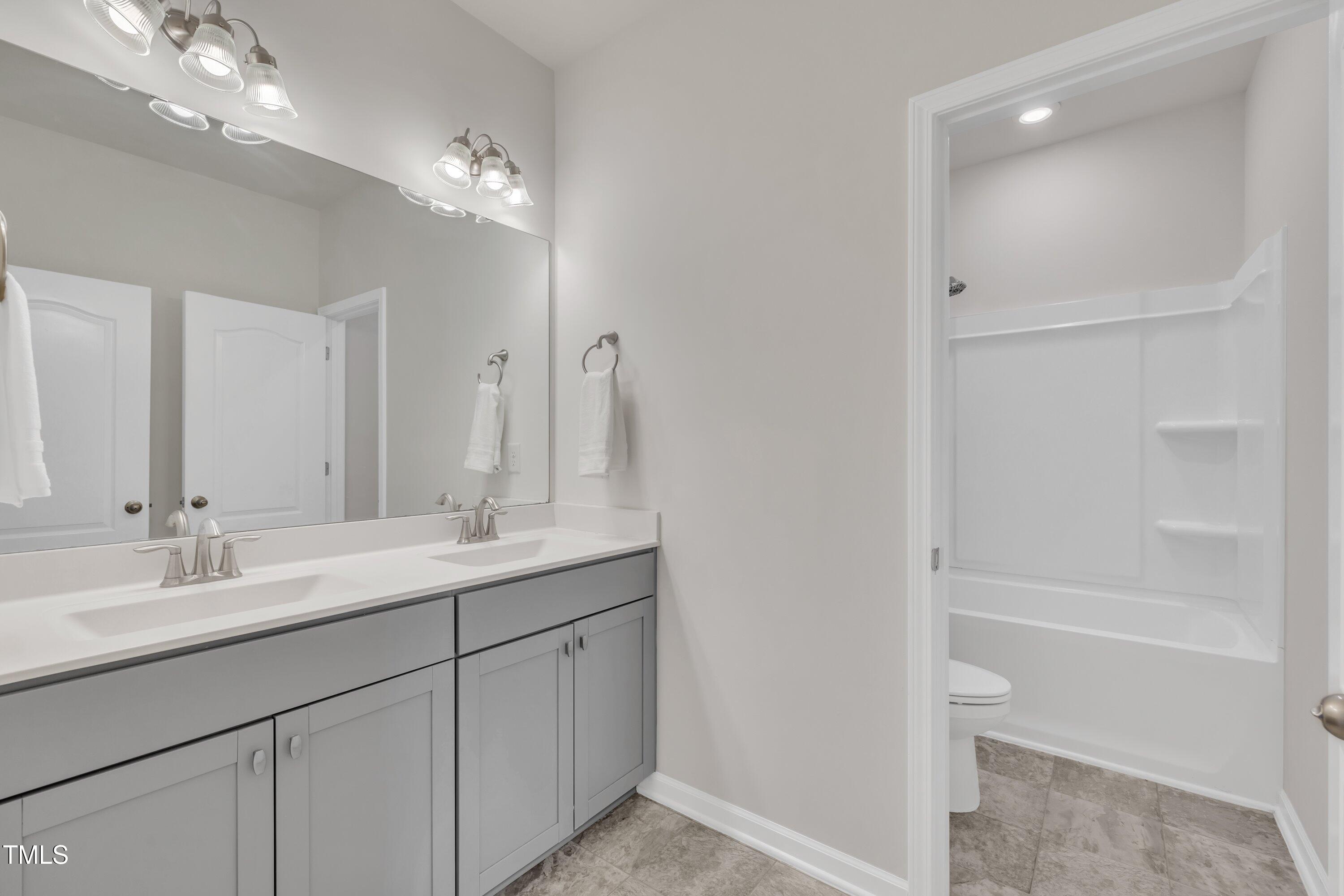 3381 Lovage Drive Apex, NC 27502 - Photo 37 of 50 a bathroom with a double vanity sink and a mirror