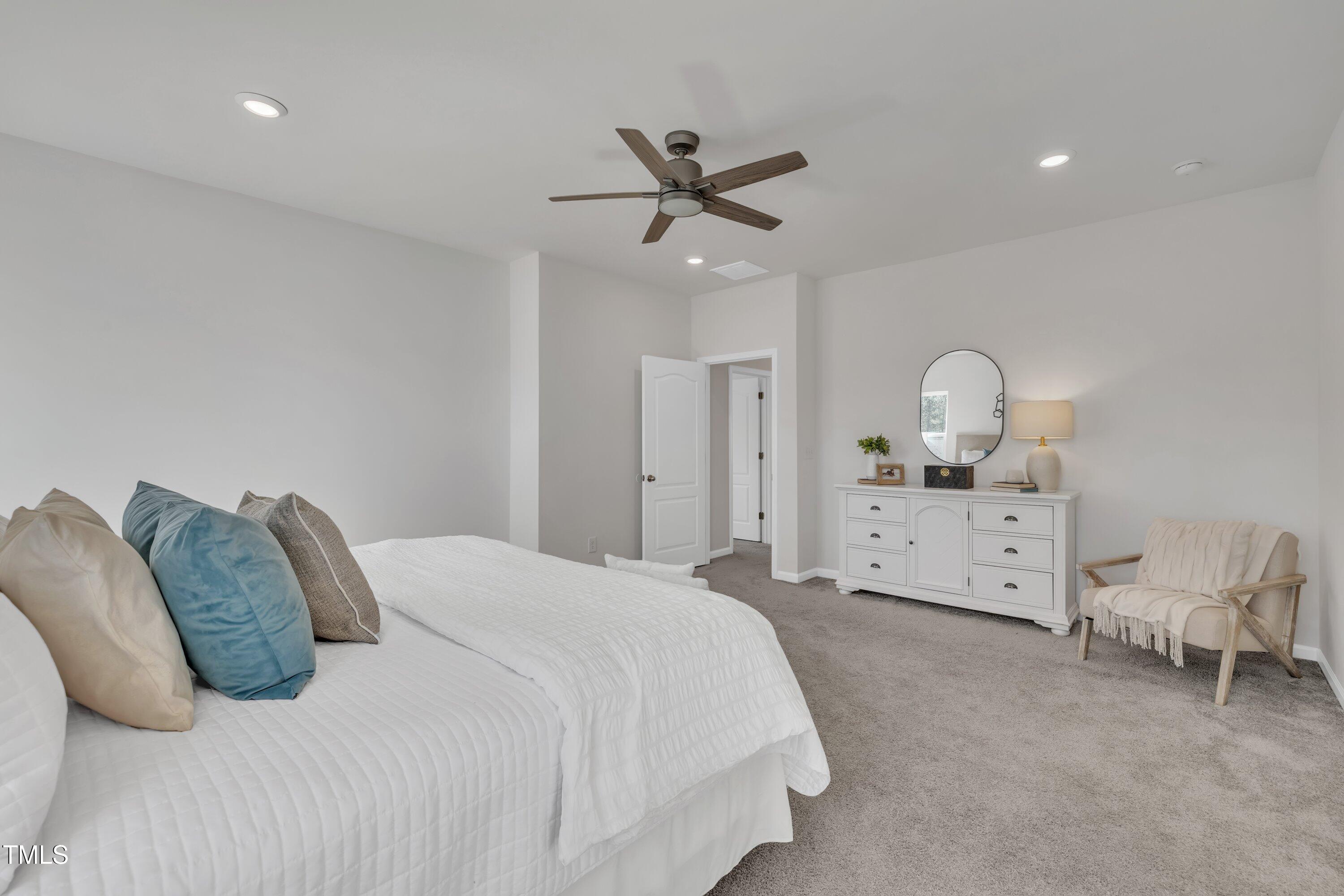 3381 Lovage Drive Apex, NC 27502 - Photo 42 of 50 a spacious bedroom with a bed and a chandelier